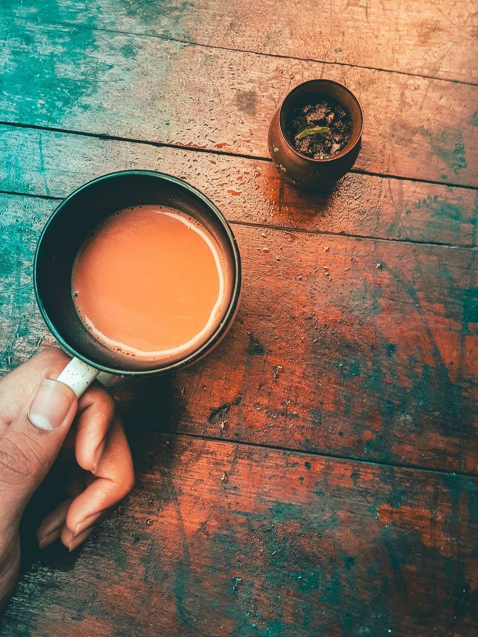 A cup of milky doodh patti chai on a painted wooden table