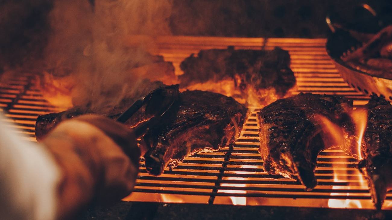 Close view of meat cooking over glowing orange embers