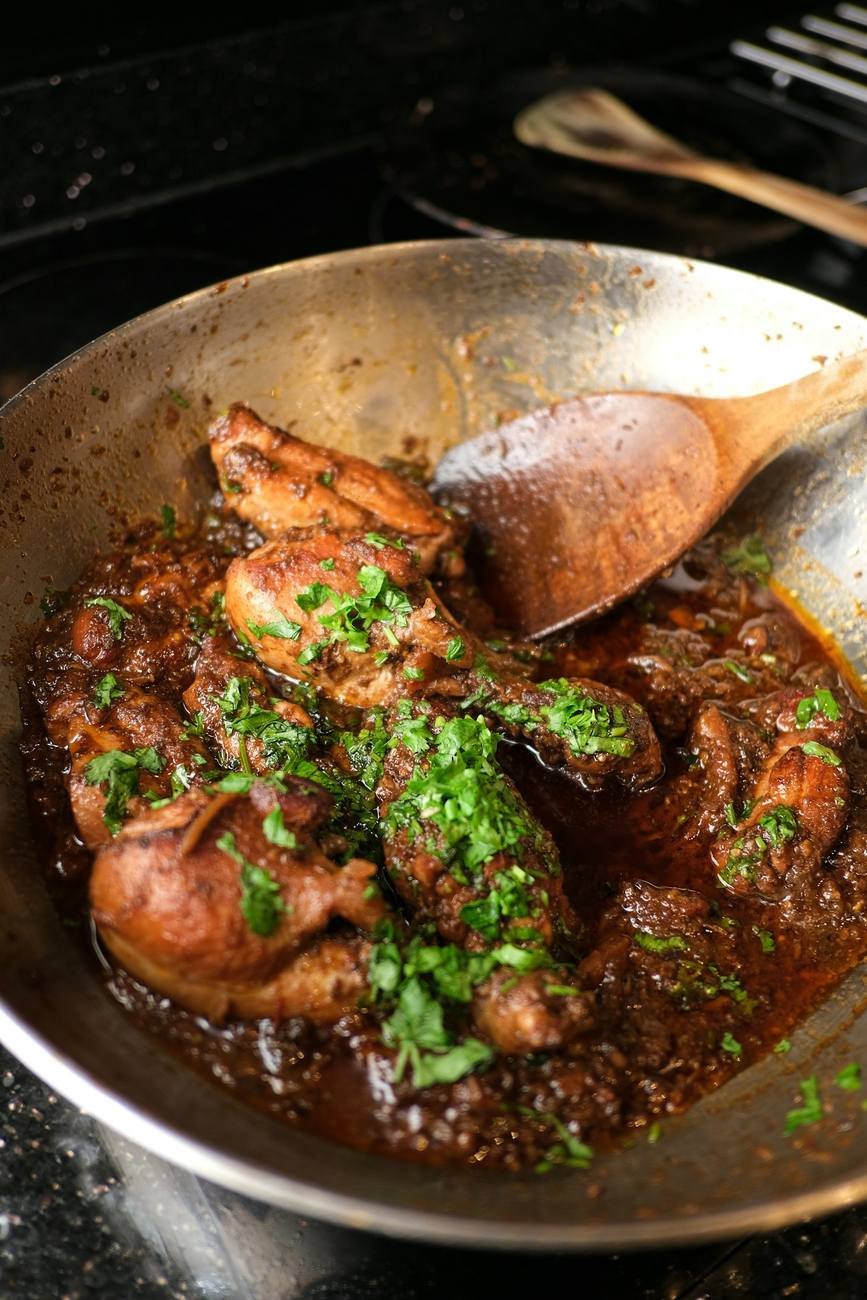 Mutton karahi bubbling in a black cast-iron pan with fresh coriander