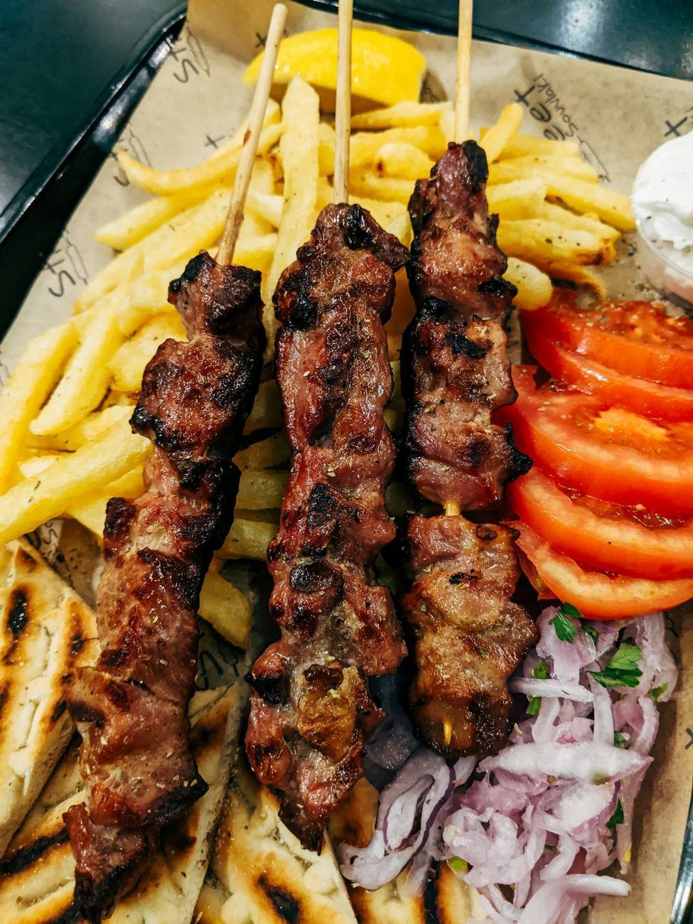 Mixed grill platter with kebabs, fries, salad and dips
