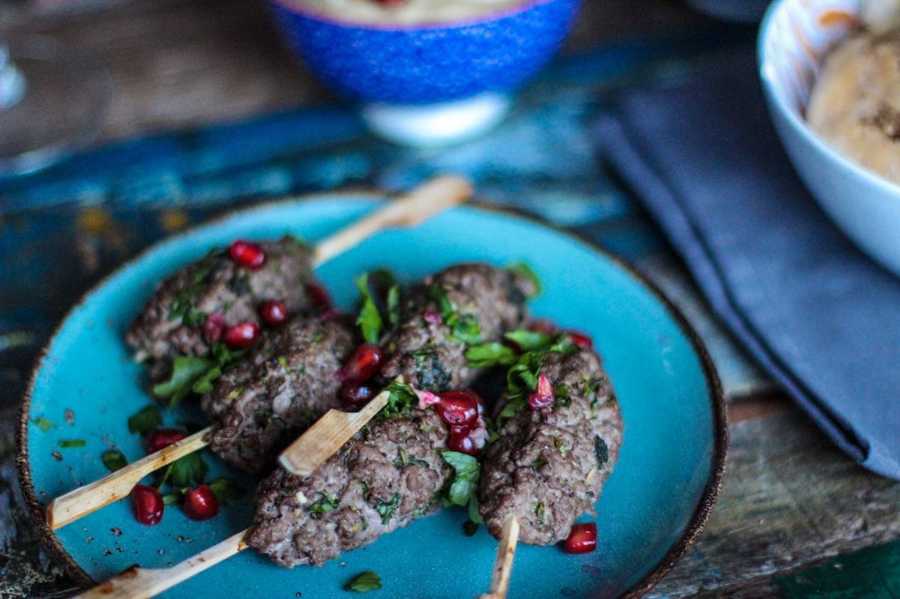 Beef seekh kebabs plated with herbs and pomegranate